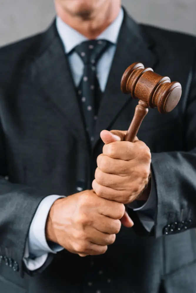 Homem de terno segurando um martelo de juíz (gavel)